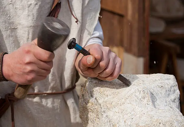 stone mason working on a rock